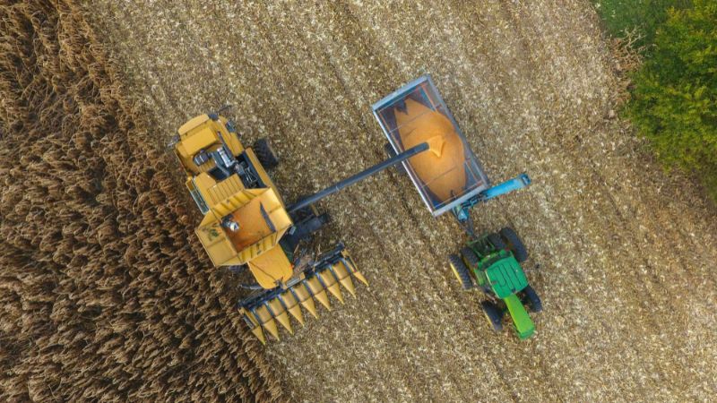 A top-down view of a grain cart and combine harvesting